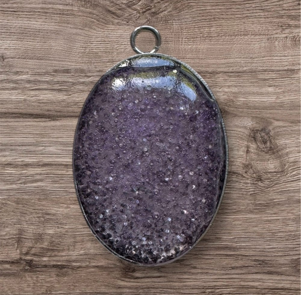 Purple crystal pendant on wood
