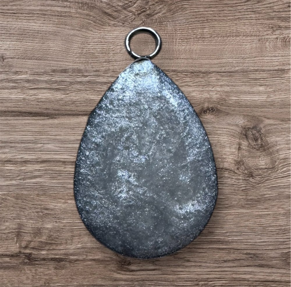 Metallic teardrop-shaped object